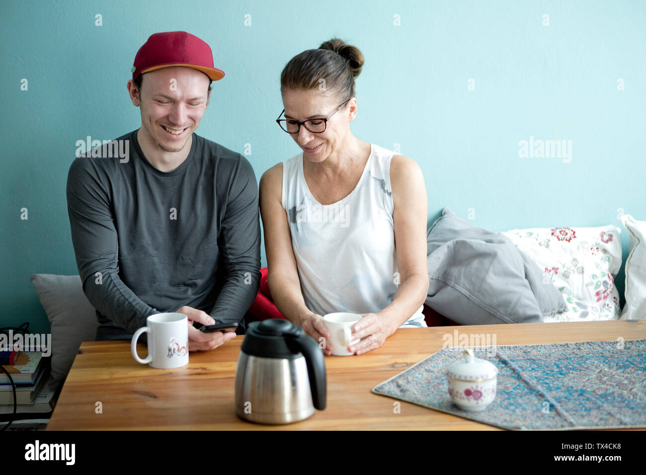 Mutter und Sohn am Küchentisch sitzen, Kaffee trinken Stockfoto