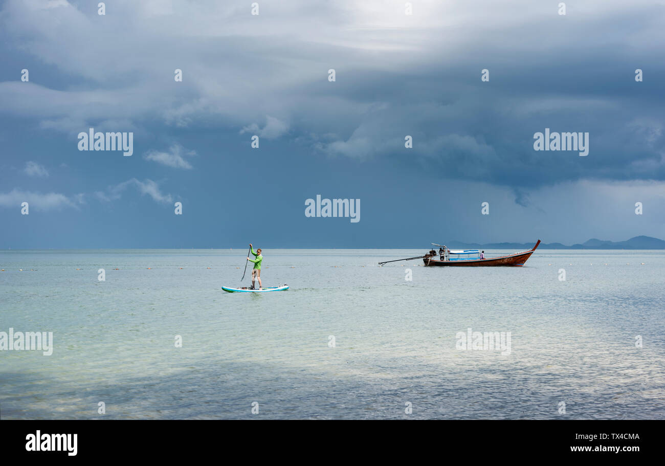 Thailand, Krabi, Lao Liang, Mann auf SUP Board im Ozean Stockfoto