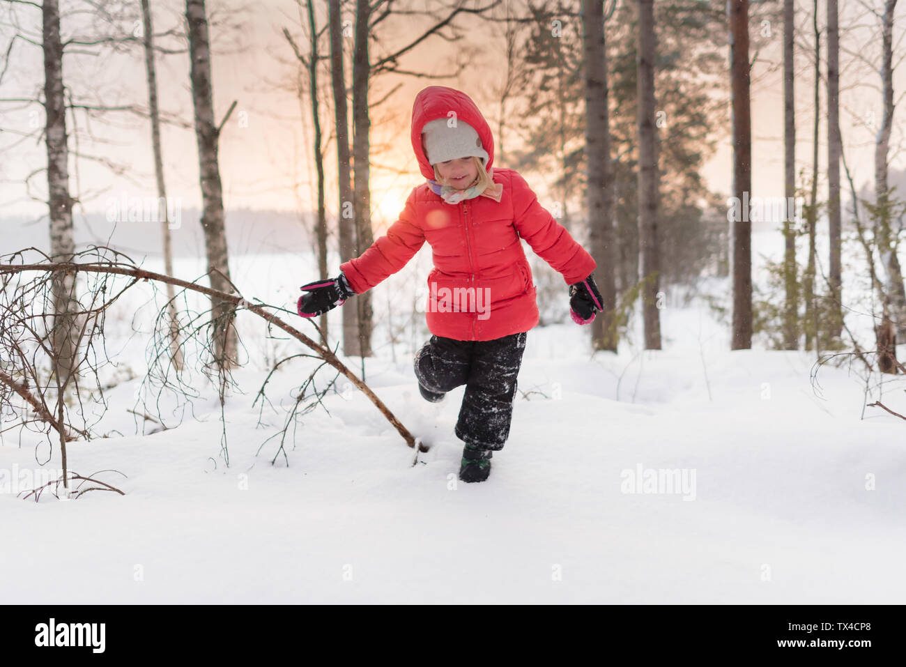 Finnland, Kuopio, glücklich Kleinkind Mädchen im Winter Landschaft bei Sonnenuntergang laufen Stockfoto