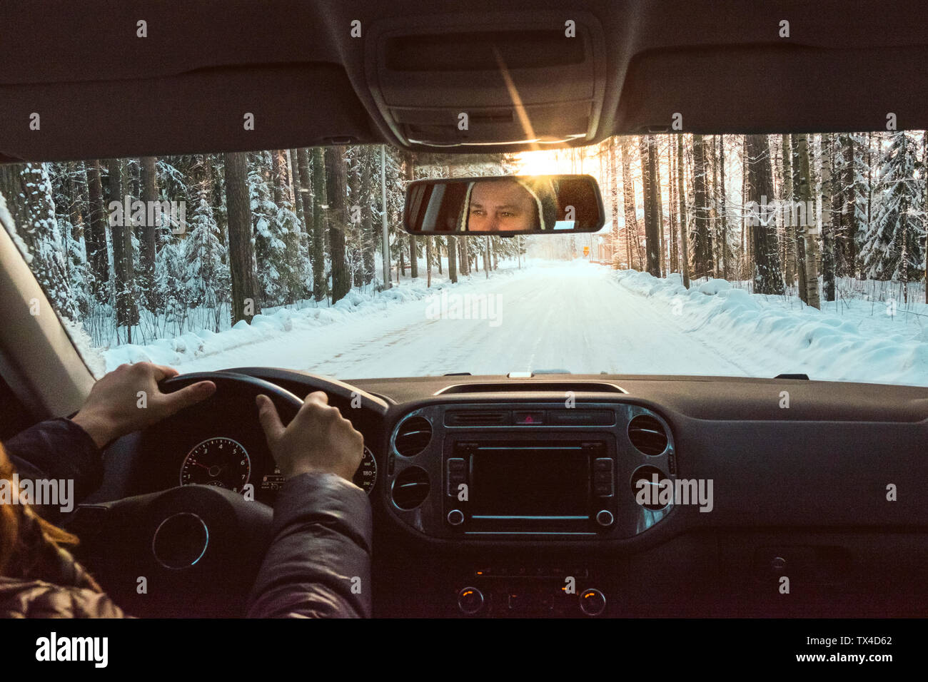 Finnland, Kuopio, Frau Autofahren im Winter Landschaft bei Sonnenuntergang Stockfoto