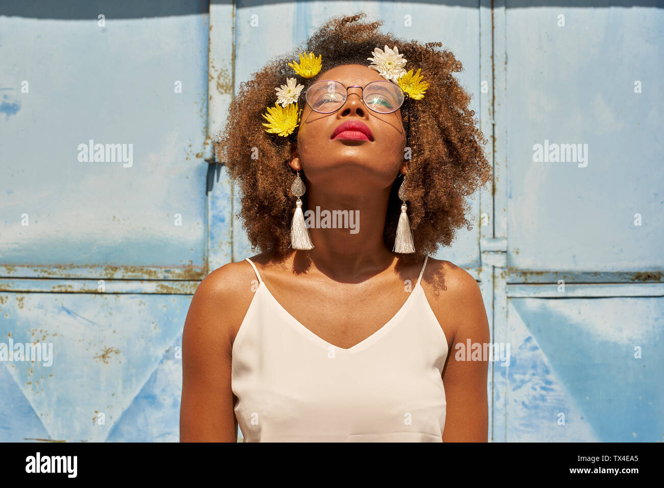 Porträt der jungen Frau mit roten Lippen Tragen einer Brille und Blumen im Haar suchen Stockfoto