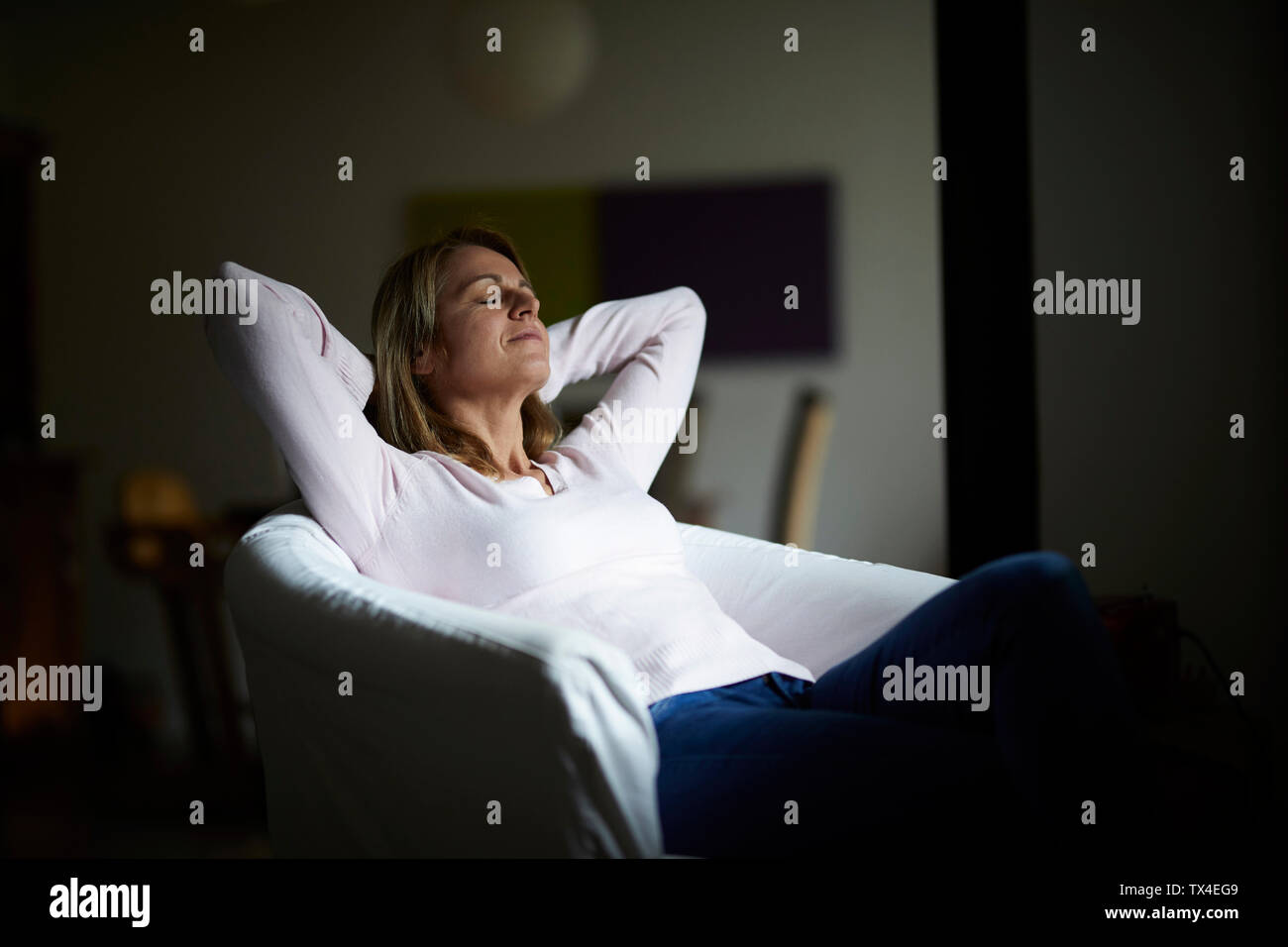 Frau sitzt zu Hause, entspannen Sie im Sessel Stockfoto