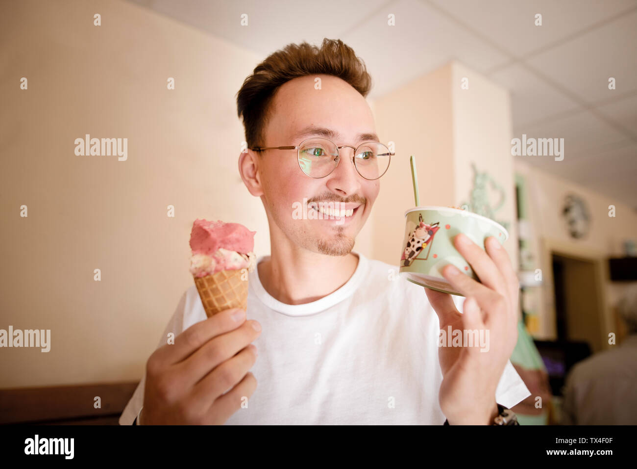 Porträt eines jungen Mannes mit Eis im Eiscafé Stockfoto