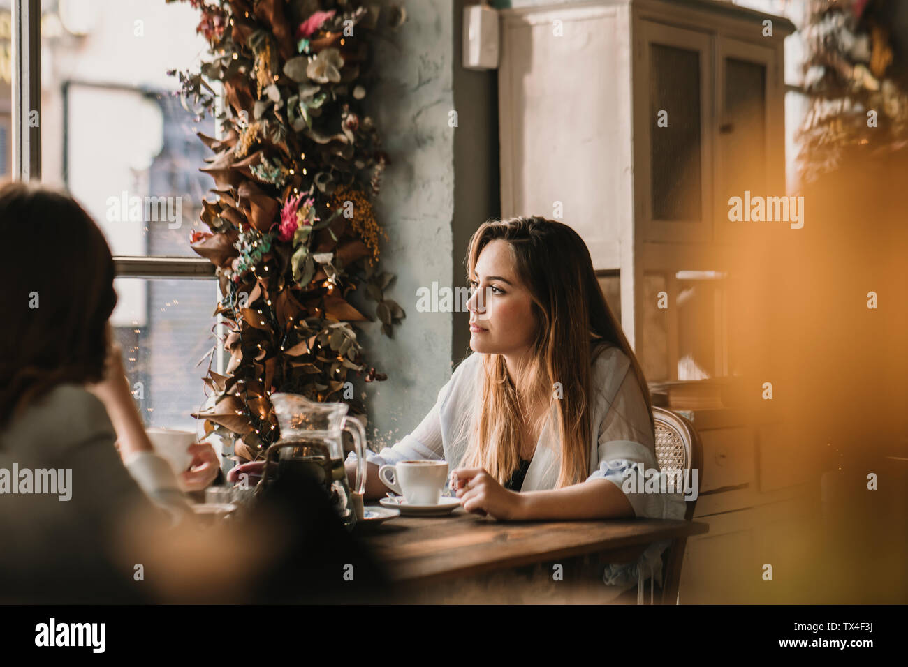 Zwei junge Frauen am Tisch sitzen in einem Cafe Stockfoto