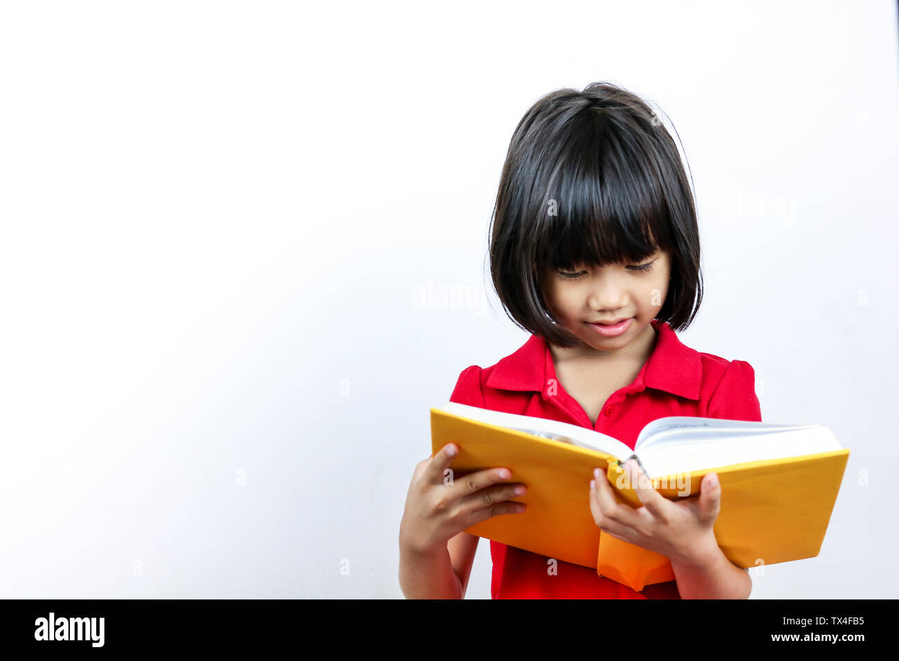 Junge asiatische Mädchen oder Frauen in roten Hemd lesen Buch, Konzept, das als Vorbereitung auf die Prüfung und Verbesserung der Intelligenz der Kid Stockfoto