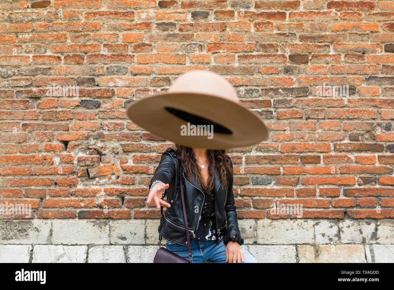 Porträt der jungen Frau mit schwarzen Lederjacke, Mauer, werfen hat Stockfoto