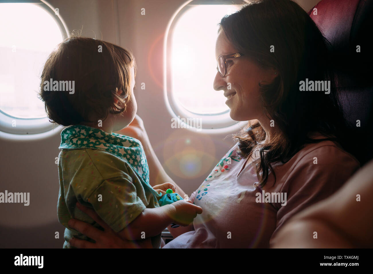Glückliche Mutter und Tochter auf Flugmodus Stockfoto