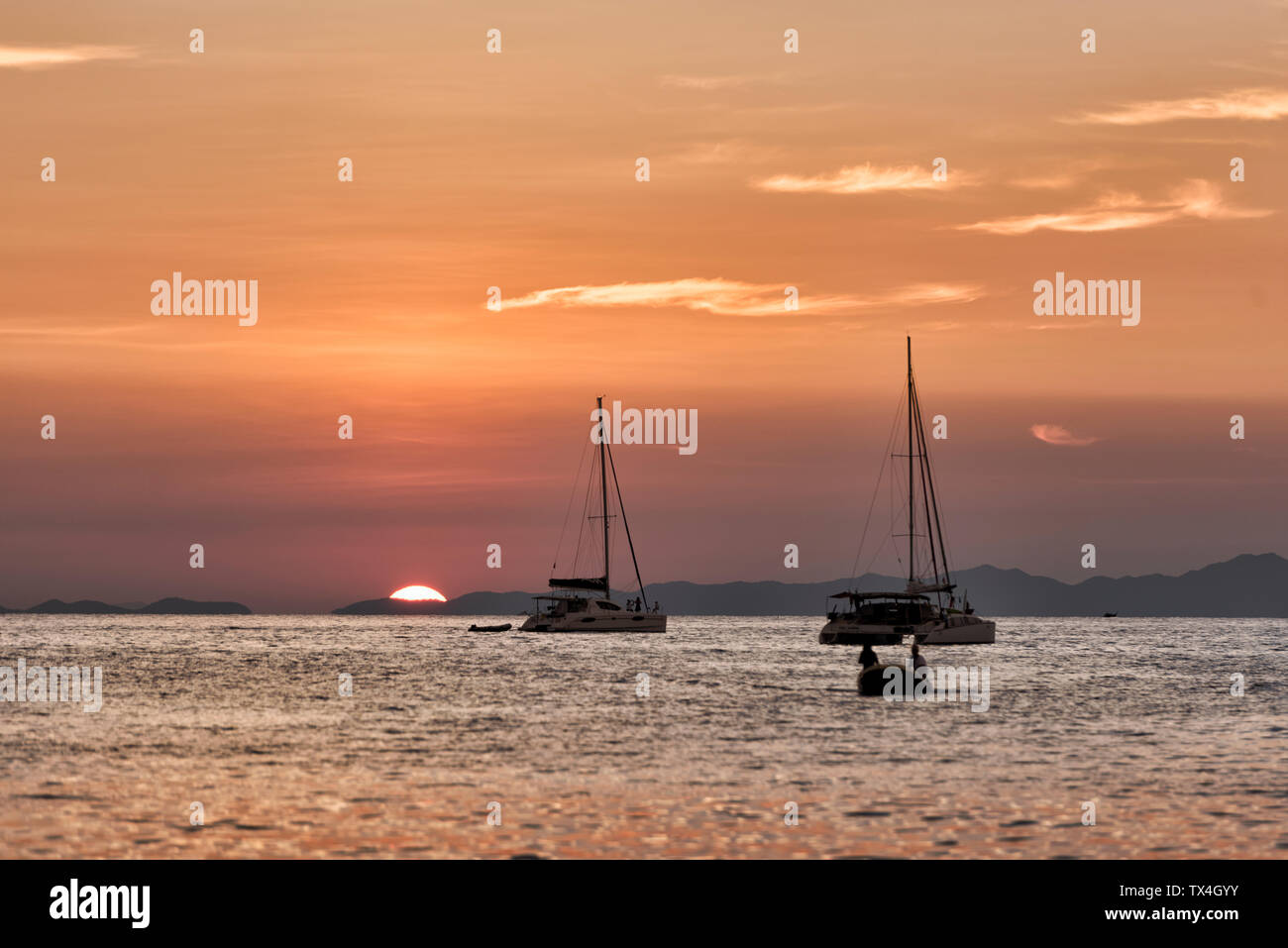 Thailand, Krabi, Railay Beach, Boote auf dem Wasser schwimmend bei Sonnenuntergang Stockfoto