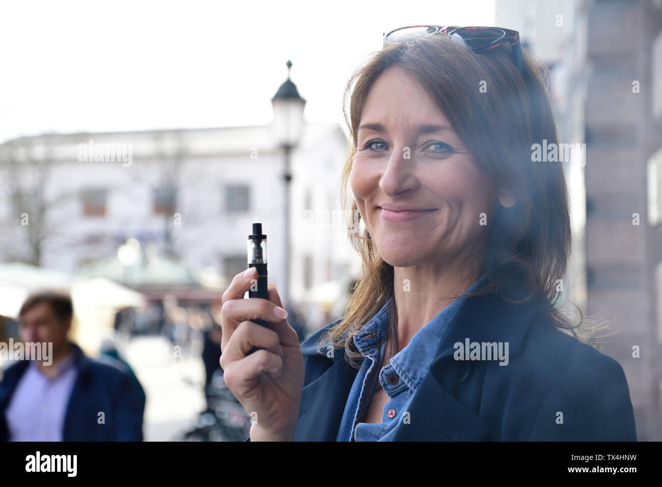 Reife Frau rauchen Elektronische Zigarette in der Stadt Stockfoto
