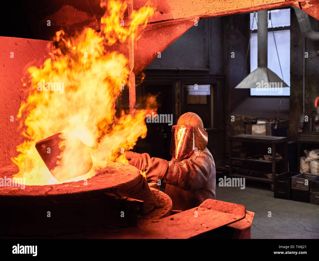 Industrie, Arbeiter am Schmelzofen beim Schmelzen von Kupfer, trug einen Brand nähe Anzug Stockfoto