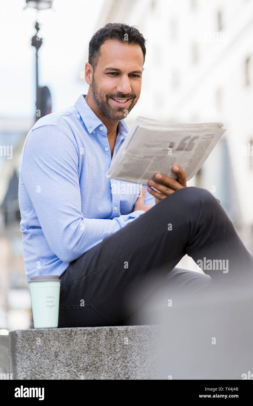 Geschäftsmann lesen Zeitung in der Stadt Stockfoto