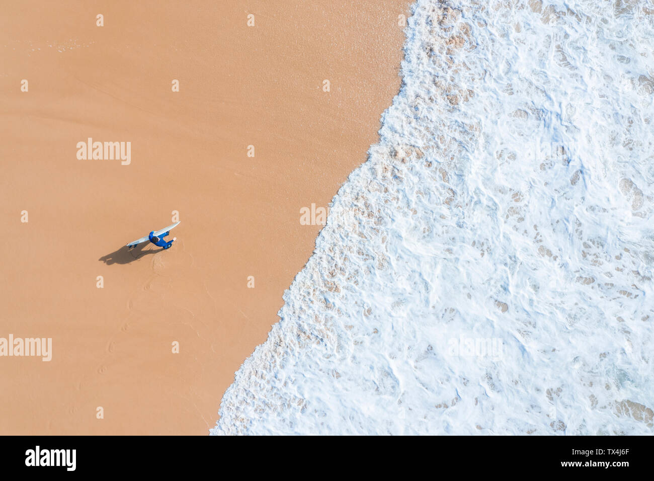 Portugal, Algarve, Lagos, Praia da Mareta, Luftaufnahme von Mann surfboard Durchführung am Strand Stockfoto