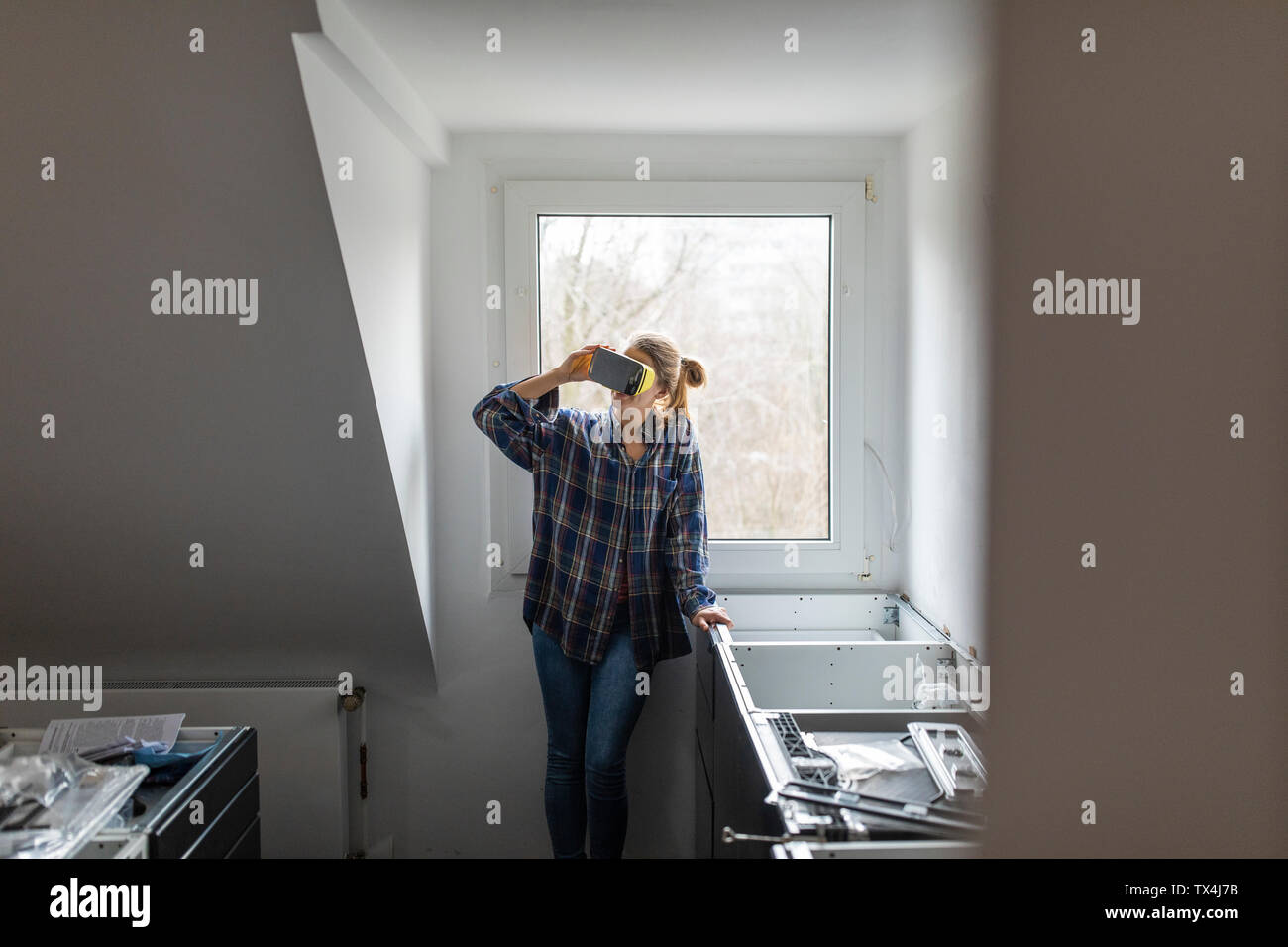 Junge Frau mit VR-Brille in unfertigen Küche Stockfoto