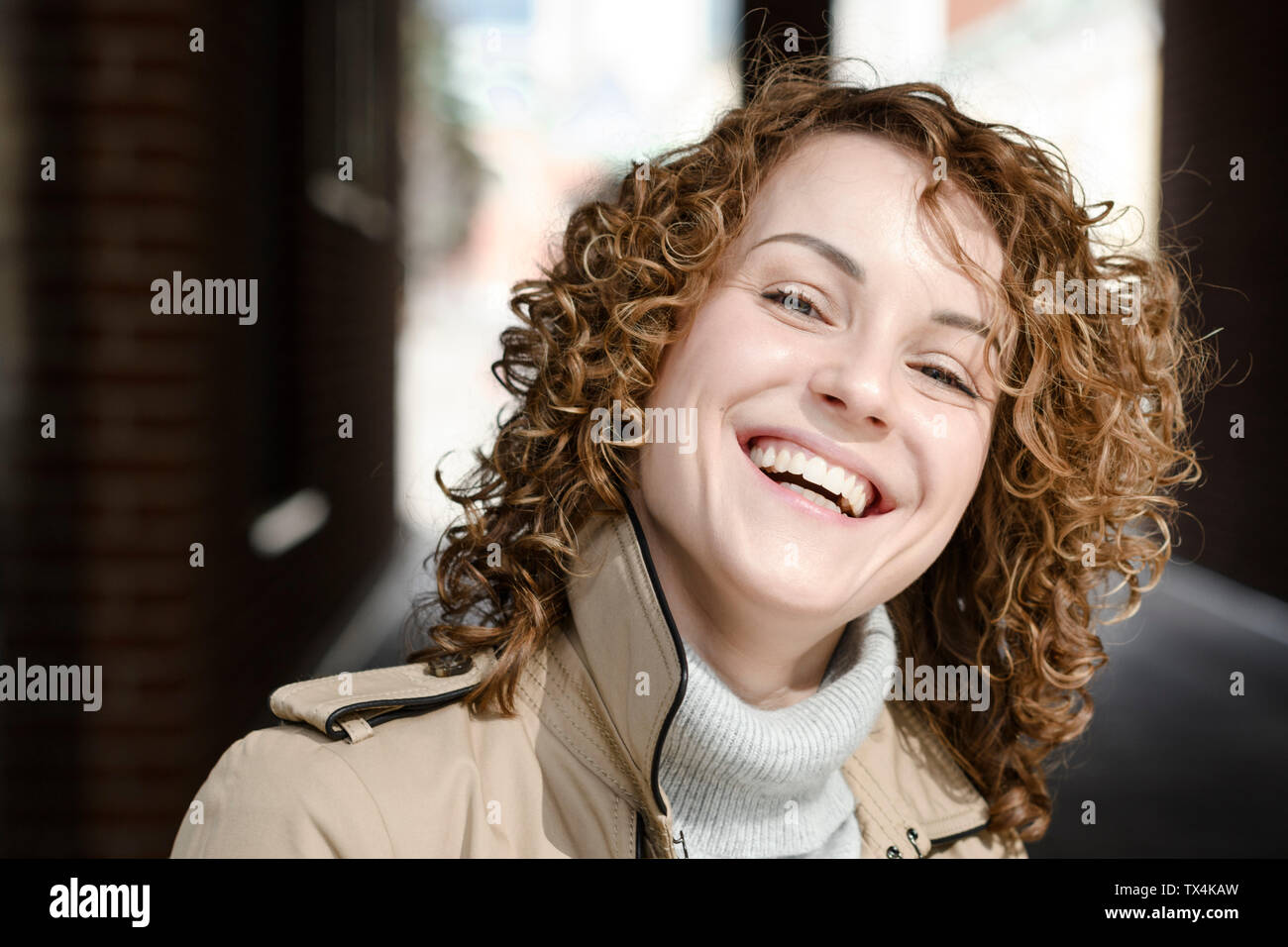 Portrait von lachende Frau mit lockigem Haar Stockfoto