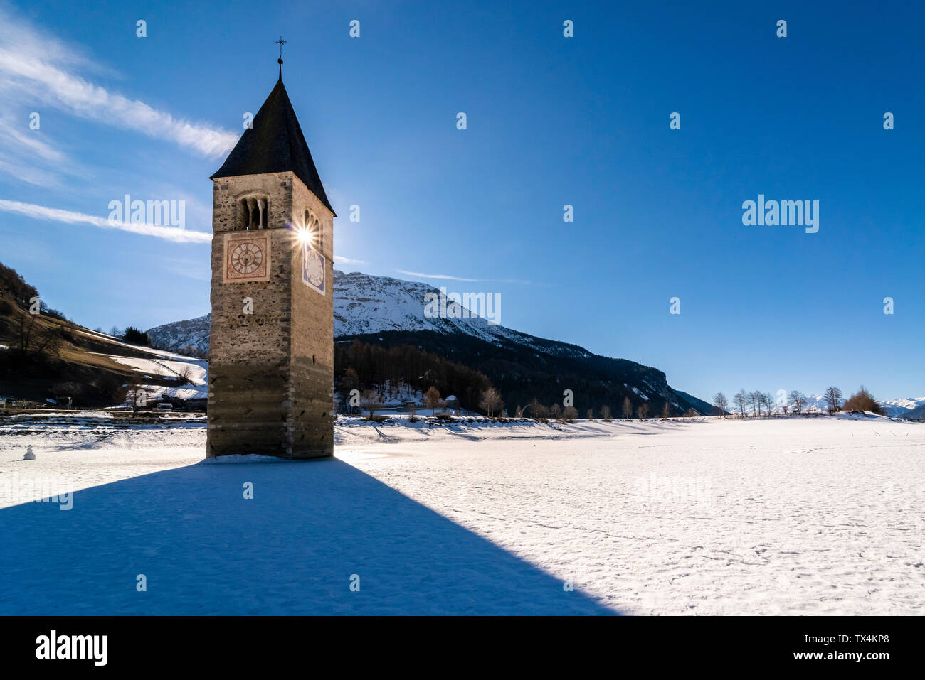 Italien, Vinschgau, versunkene Turm in gefrorenen Lago di Resia im Winter Stockfoto