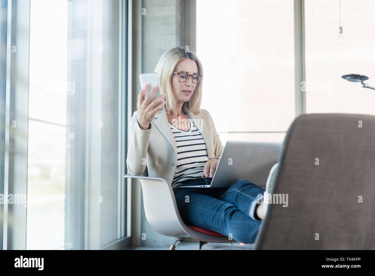 Entspannt Geschäftsfrau mit Laptop im Büro mit Fuß oben Stockfoto