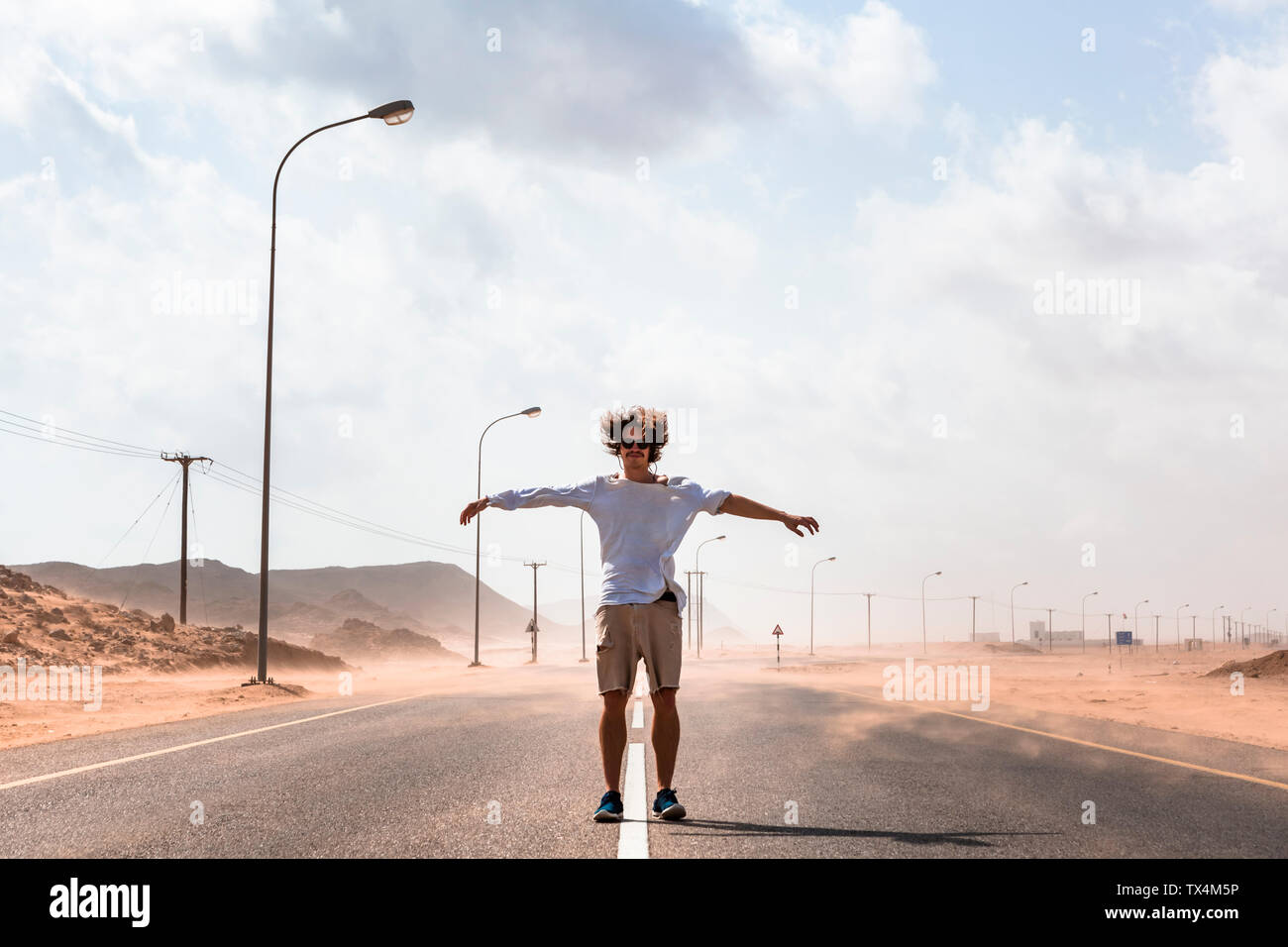 Sultanat Oman Ras al Hadd, Desert Road, Mann in einem Sandsturm Stockfoto