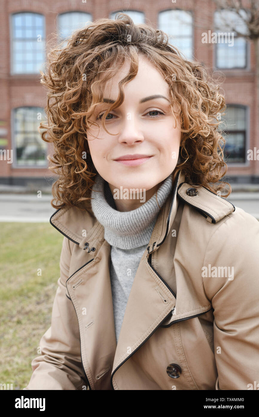 Porträt der lächelnde Frau mit lockigem Haar Stockfoto
