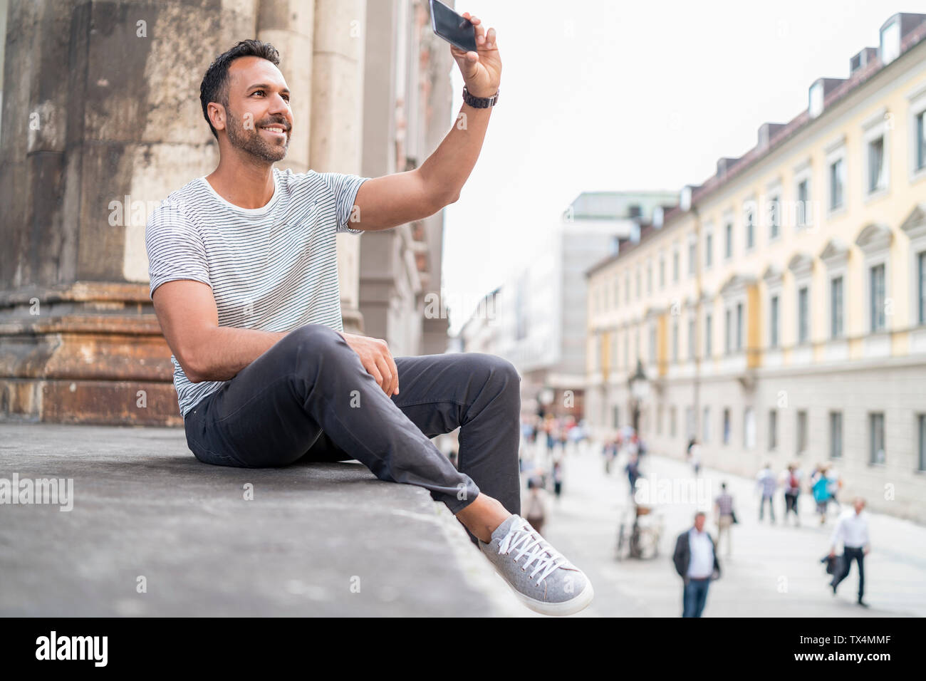 Lächelnd Mann einen selfie in der Stadt Stockfoto