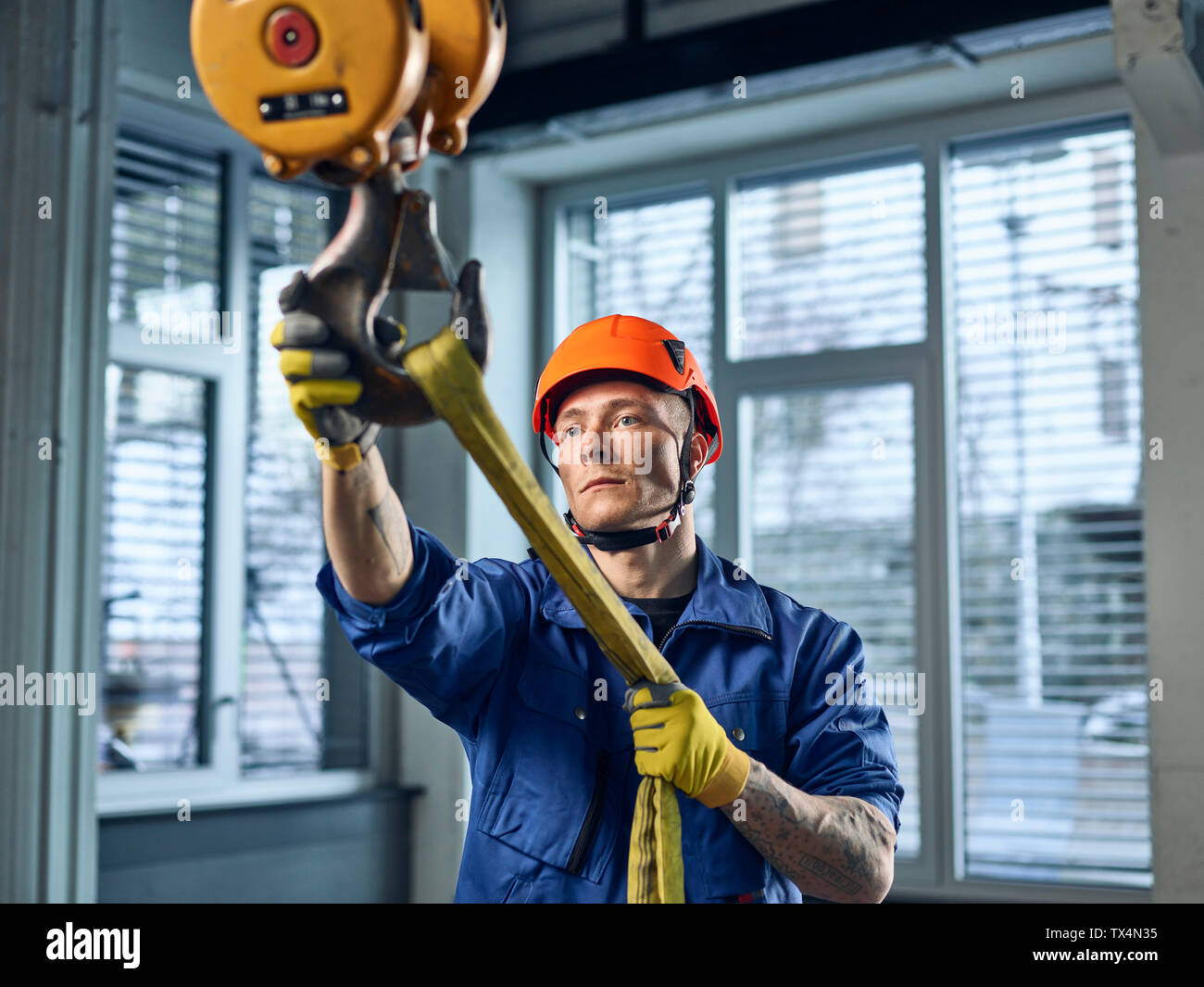 Industrielle Arbeiter zur Festsetzung hoist Sling auf Hallenkran Stockfoto