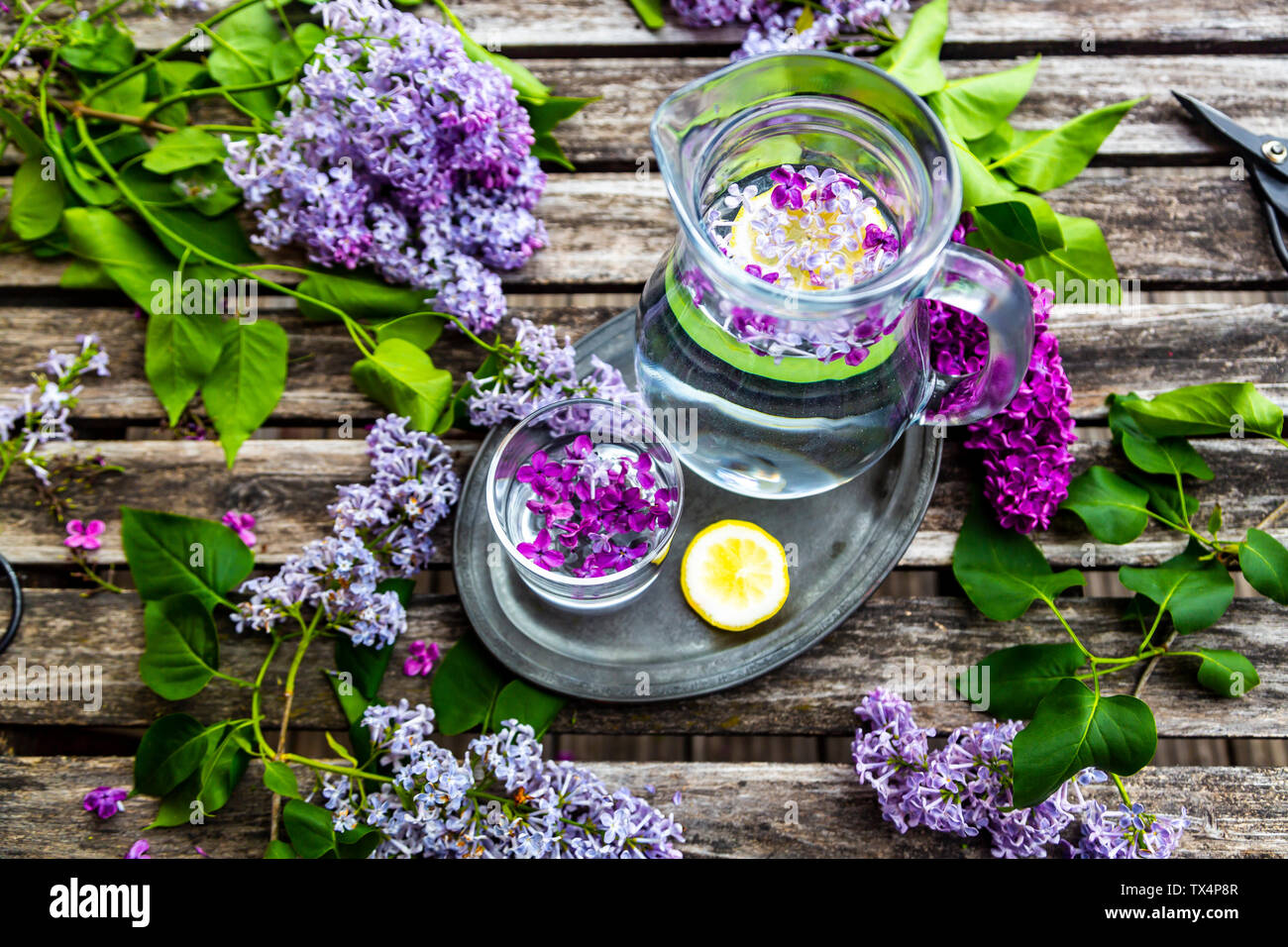 Glas mit Glas Wasser mit lila, Sirup und Zitrone Stockfoto