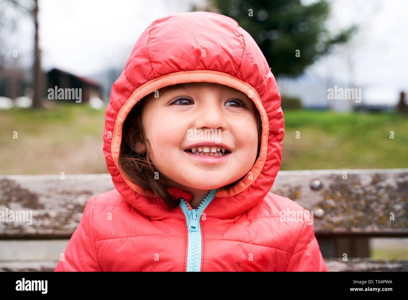 Portrait von glücklich Kleinkind Mädchen mit roten Daunenjacke mit Kapuze Stockfoto