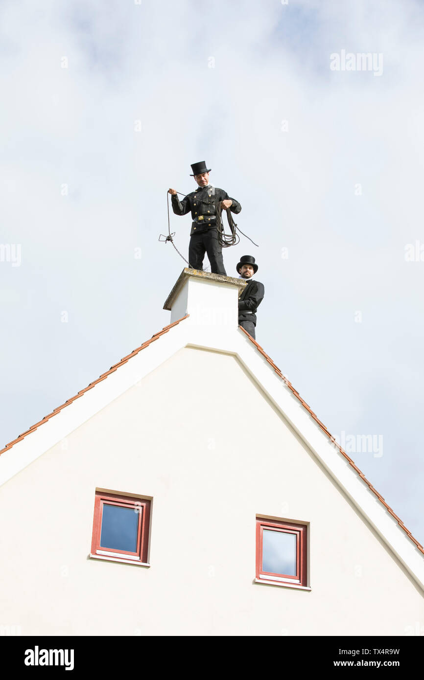 Zwei Schornsteinfeger Arbeiten am Haus Dach Stockfoto