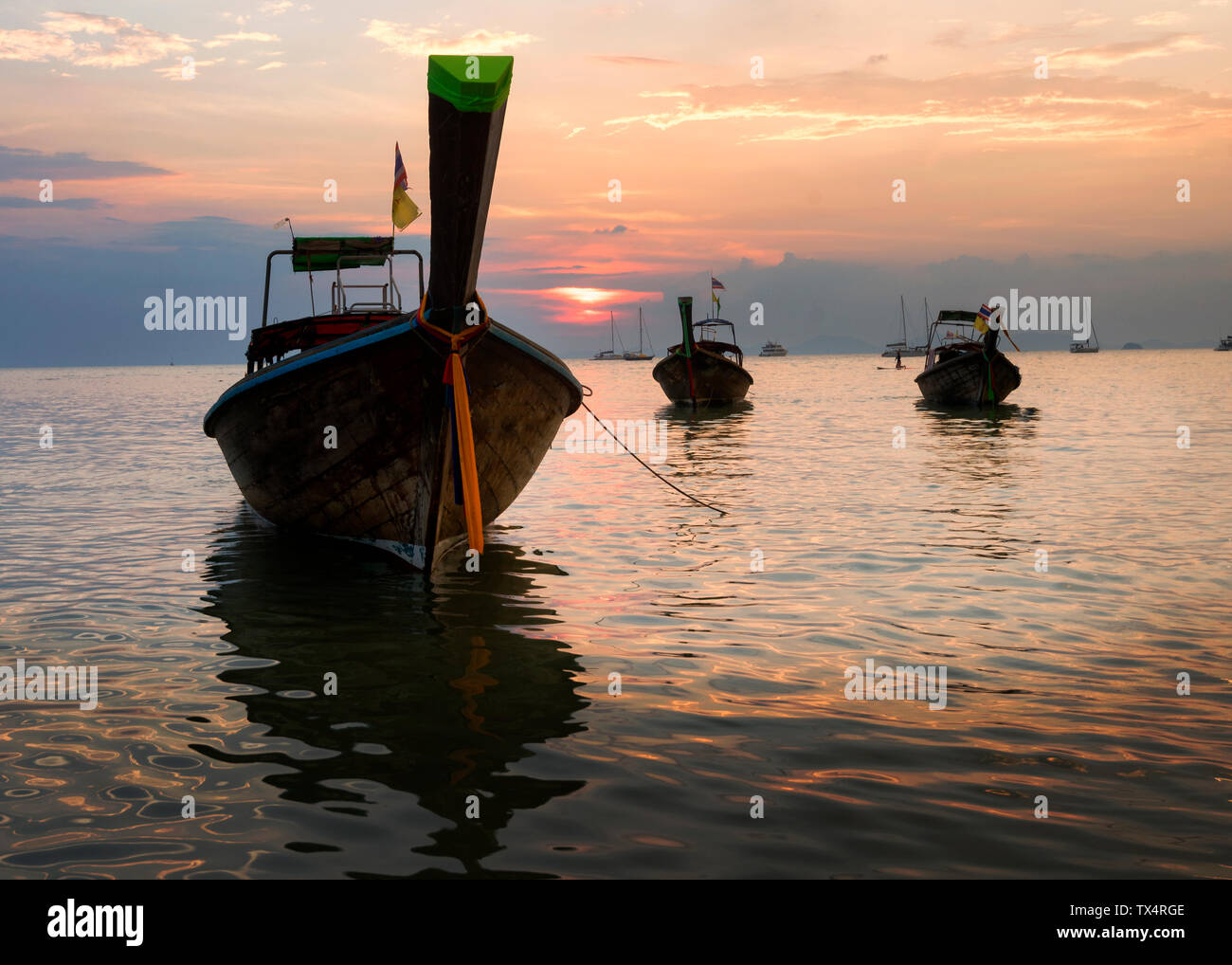 Thailand, Krabi, Railay Beach, Long-tail Boote auf dem Wasser schwimmend bei Sonnenuntergang Stockfoto