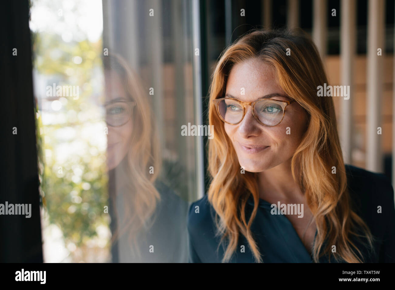 Portrait von lächelnden Geschäftsfrau Blick aus Fenster Stockfoto