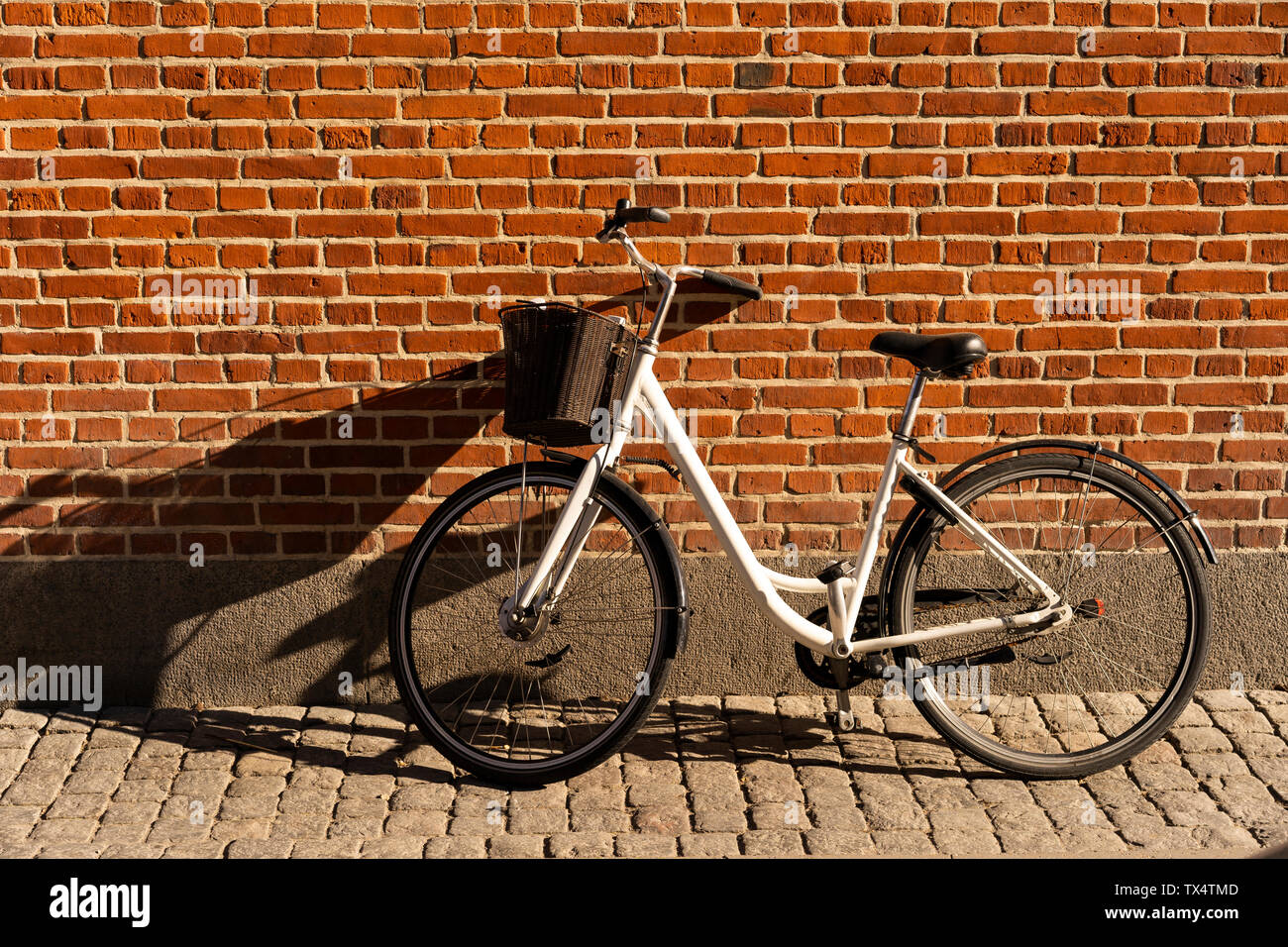 Dänemark, Kopenhagen, Fahrrad gegen die Wand im Sonnenlicht schiefen Stockfoto