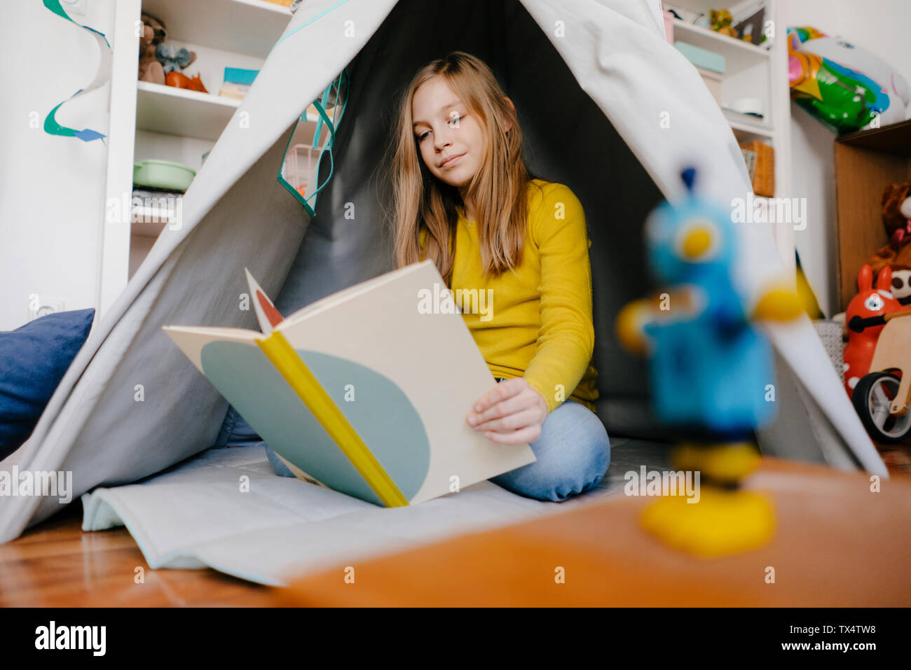 Mädchen zu Hause lesen Buchen Sie im Kinderzimmer Stockfoto