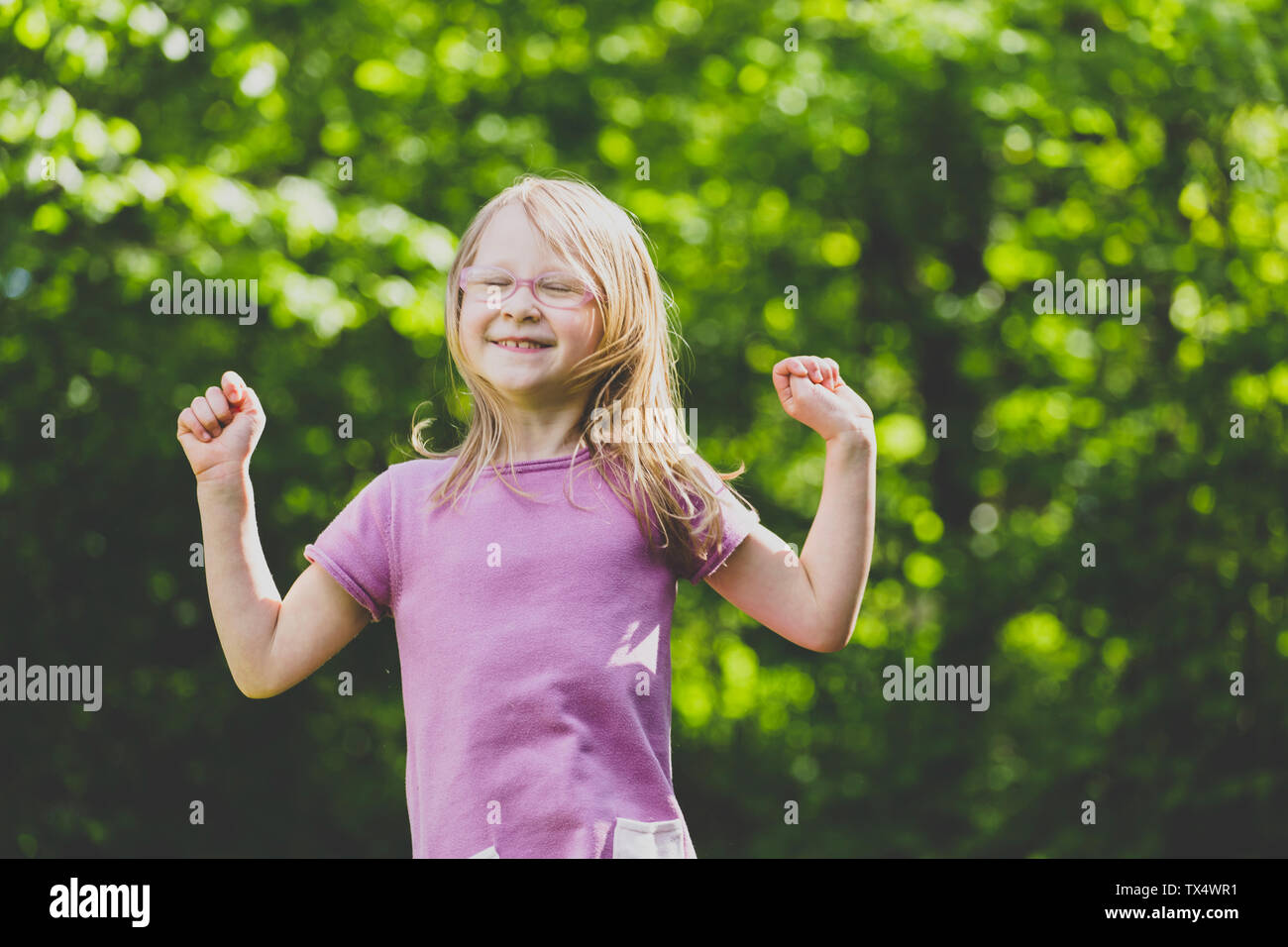 Ein springendes Vorschule Mädchen mit geschlossenen Augen Stockfoto