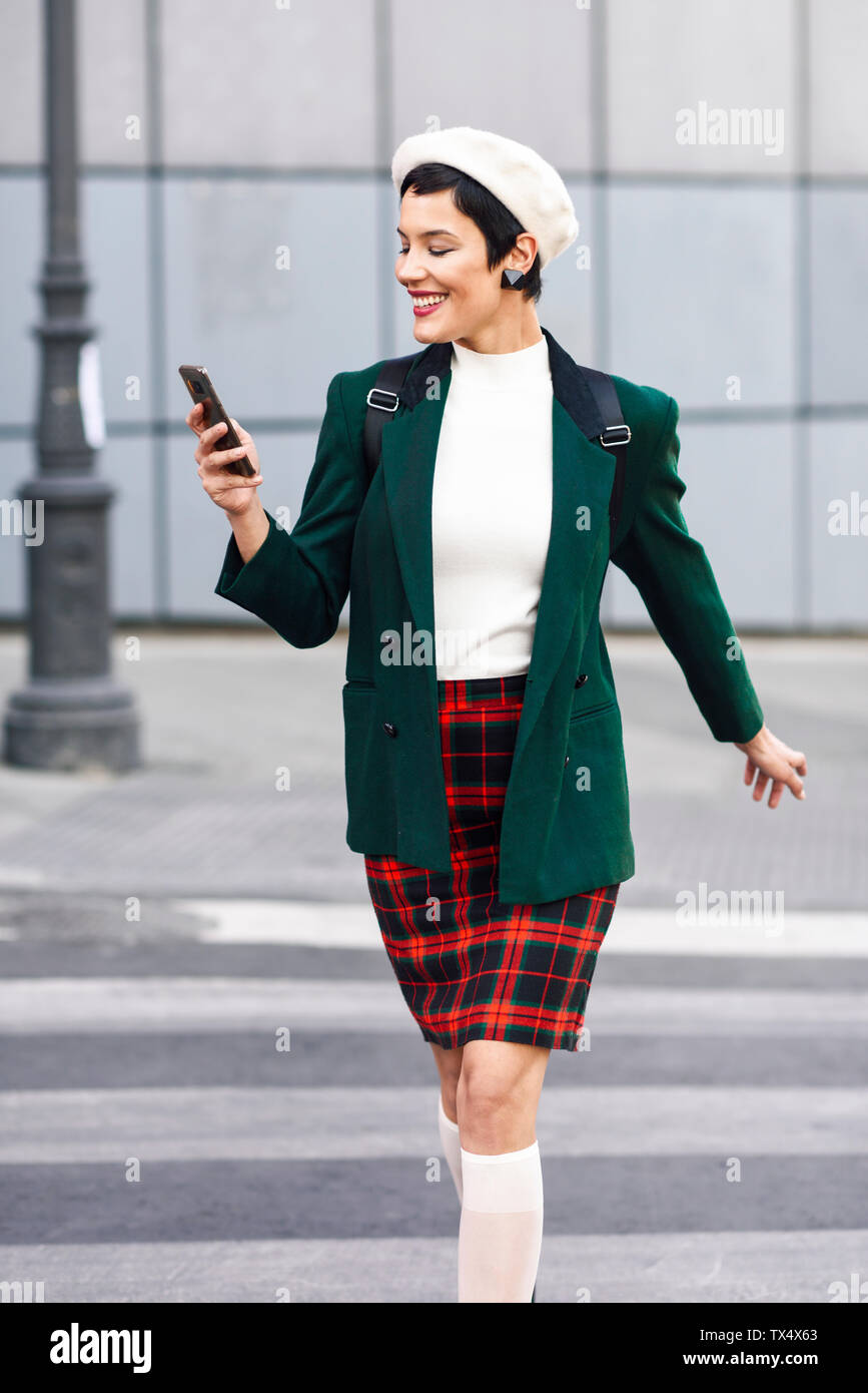 Modische junge Frau mit Handy Kreuzung zebra crosssing Stockfoto