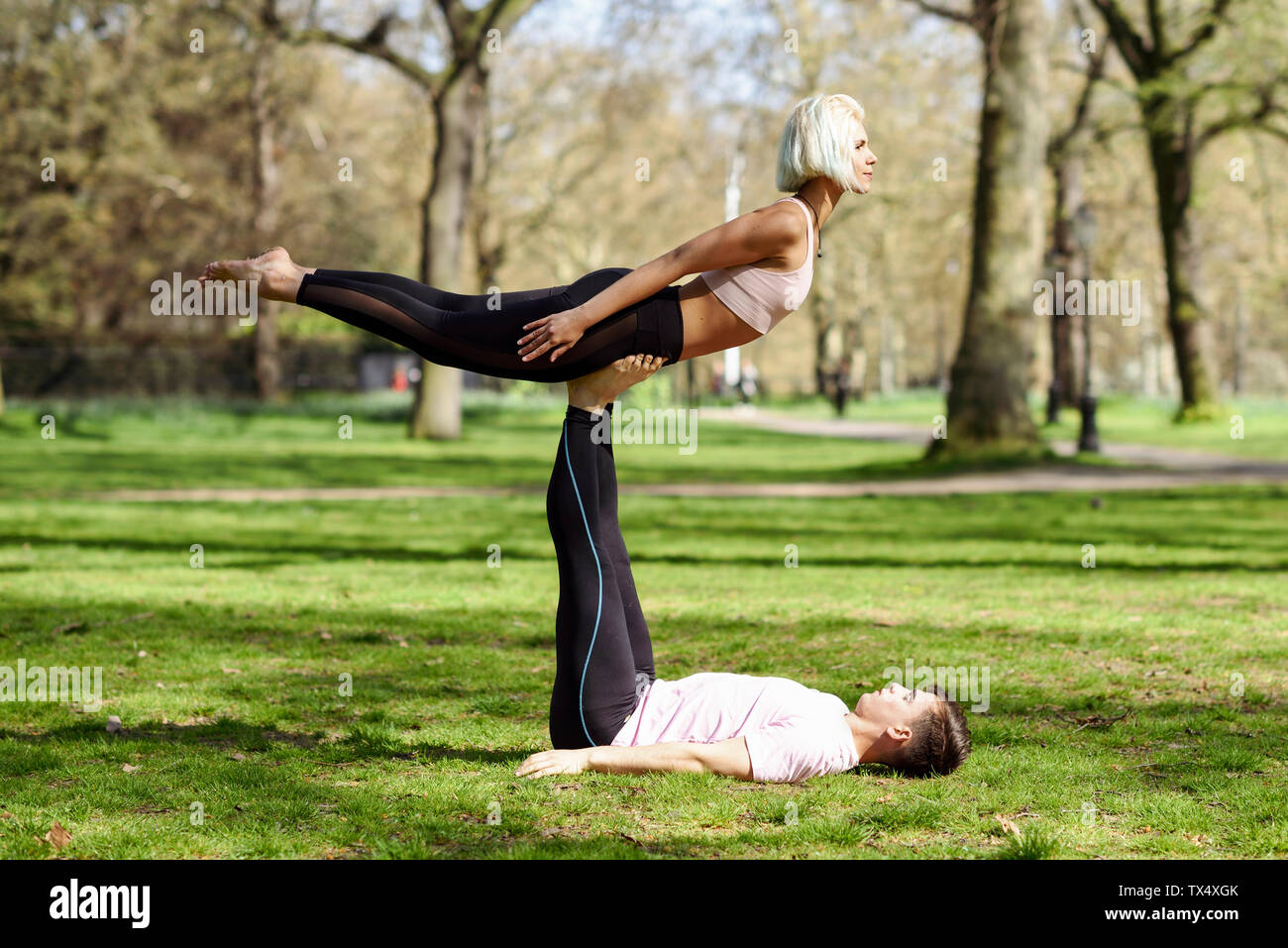 Junges Paar yoga Akrobatik in einem städtischen Park Stockfoto