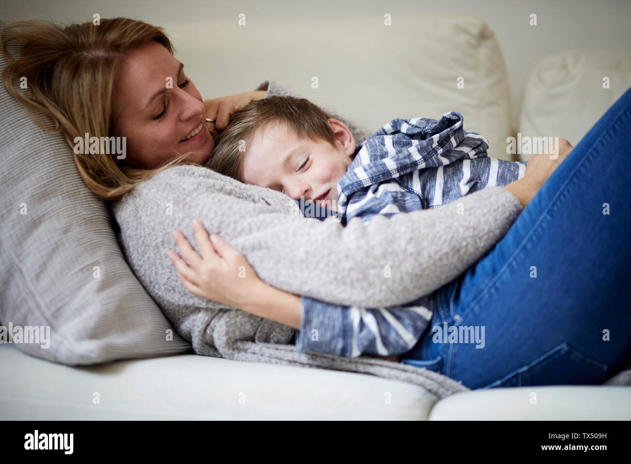 Mutter und Sohn kuscheln auf der couch Stockfoto