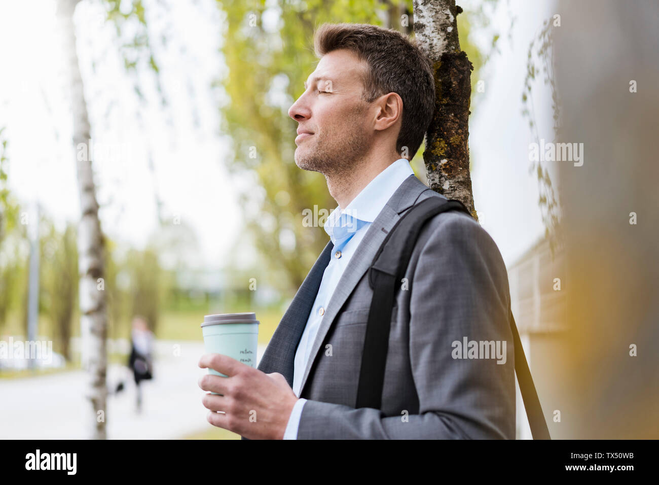 Entspannt Geschäftsmann mit Takeaway Kaffee in einem Park Stockfoto