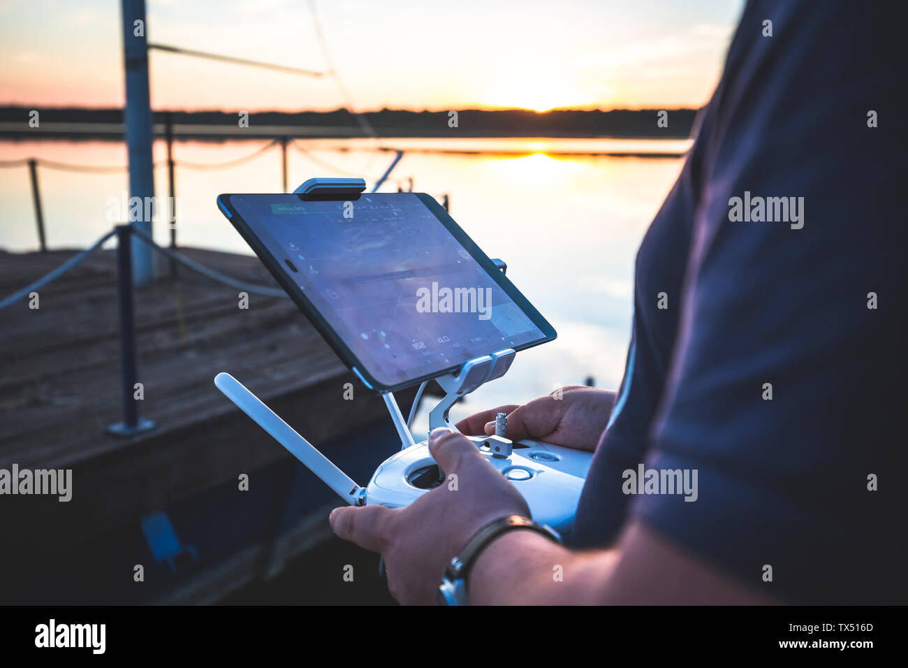 Mann fliegende Drohne, holding Kontrolle bei Sonnenuntergang Stockfoto