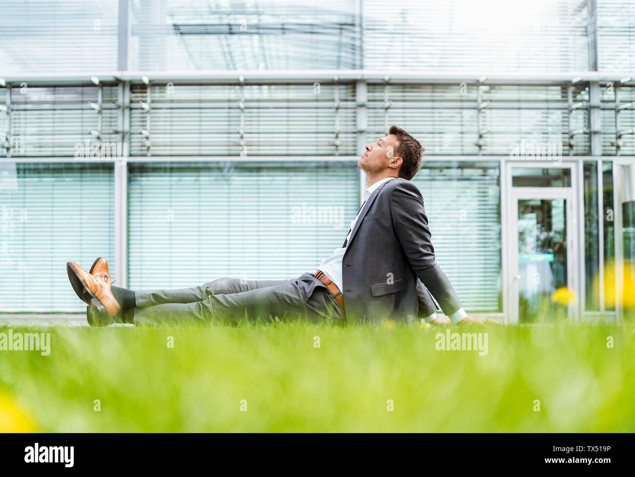 Entspannt Geschäftsmann mit einer Unterbrechung im Gras sitzen Stockfoto