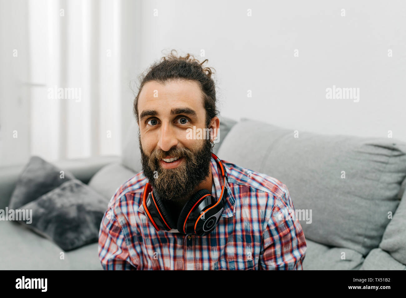 Portrait von bärtigen Mann mit Kopfhörern zu Hause Stockfoto