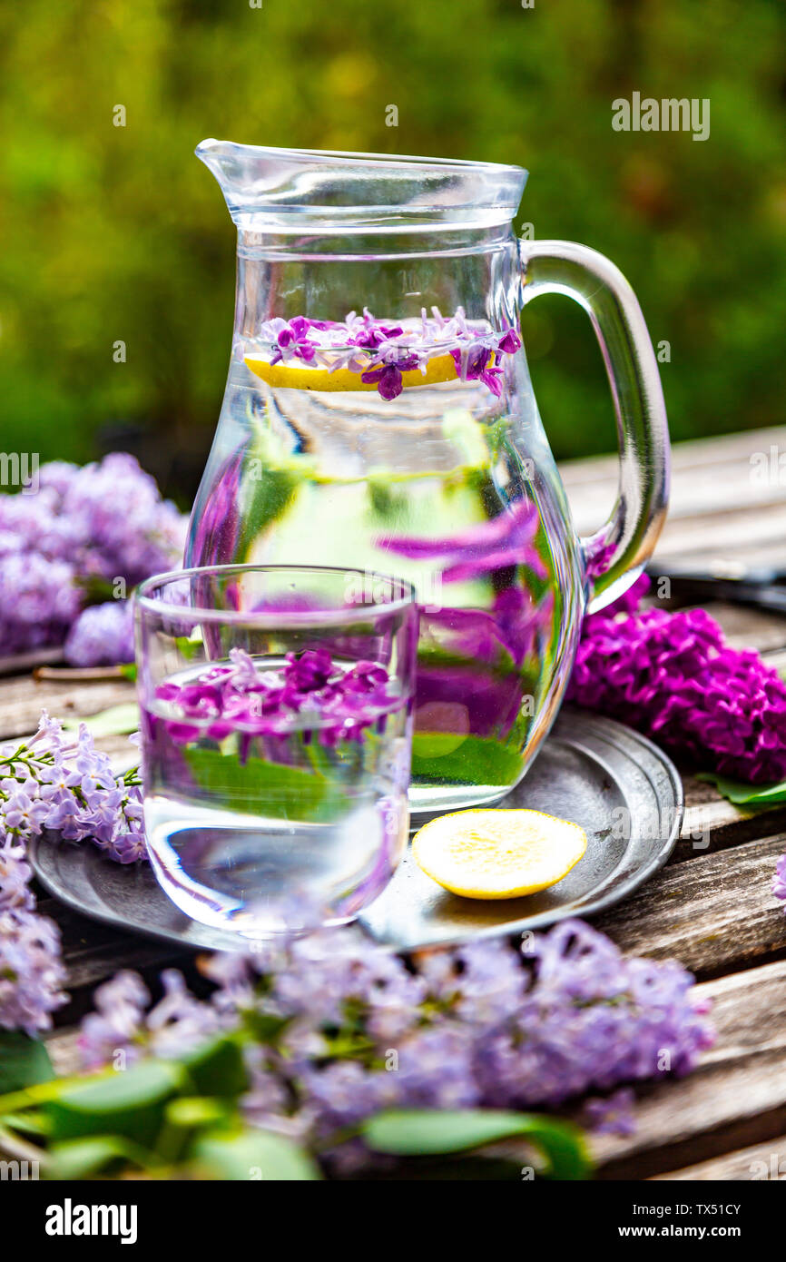 Glas mit Glas Wasser mit lila, Sirup und Zitrone Stockfoto