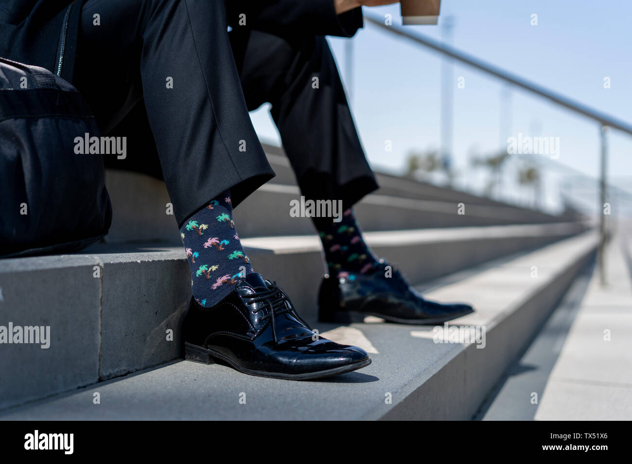 In der Nähe - upof Geschäftsmann sitzt auf der Treppe tragen gemusterte Socken Stockfoto