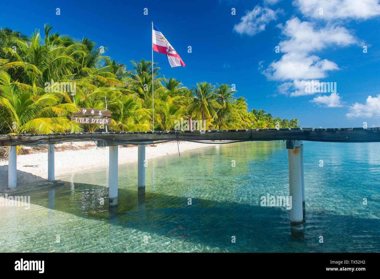 Französisch Polynesien, Tuamotus, Tikehau, Pier im Palm Beach mit Fahne Stockfoto