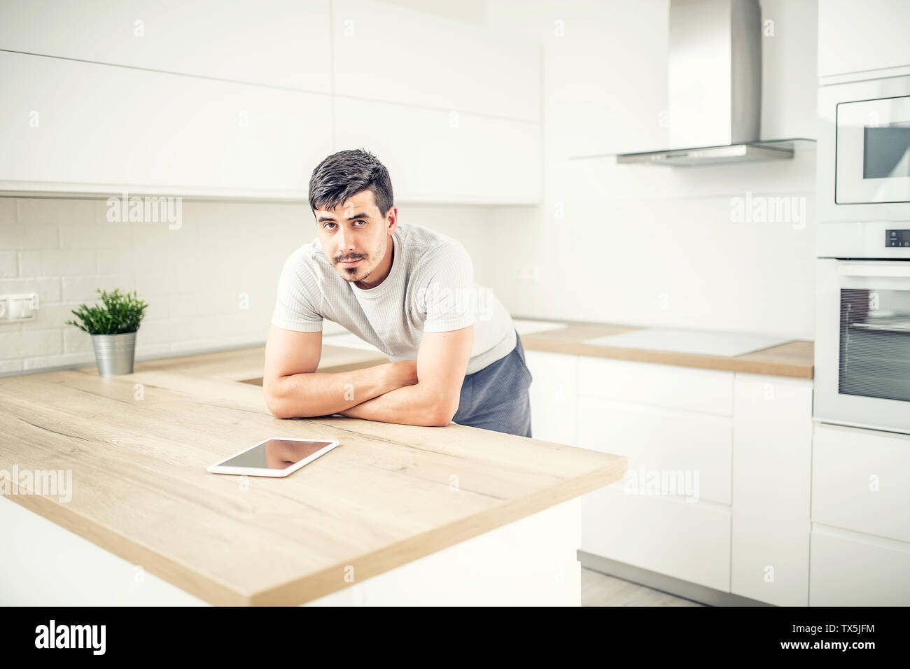 Junge Mann in der Küche zu Hause mit Tablet. Stockfoto
