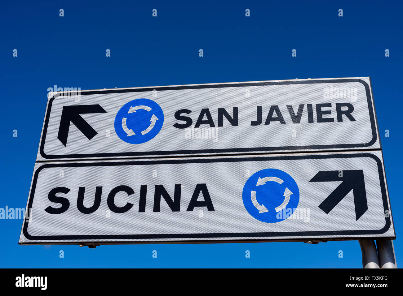 Straßenschild am Kreisverkehr mit Wegbeschreibung nach San Javier und Sucina. Blauer Himmel. Richtungspfeil. Richtungspfeile Stockfoto