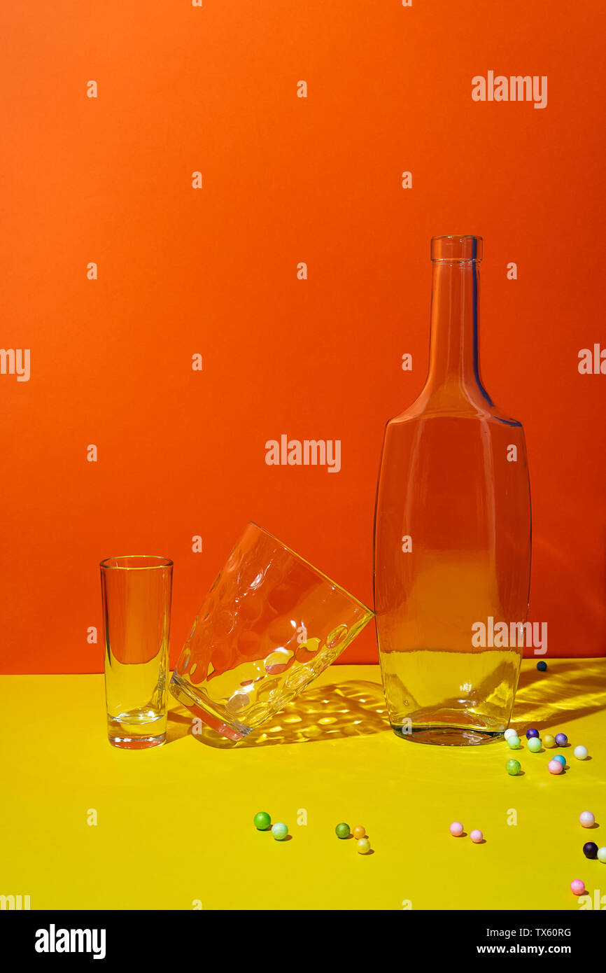 Pop Art noch gestalteten Leben mit leeren Flaschen und Gläser auf Orange und Gelb Stockfoto