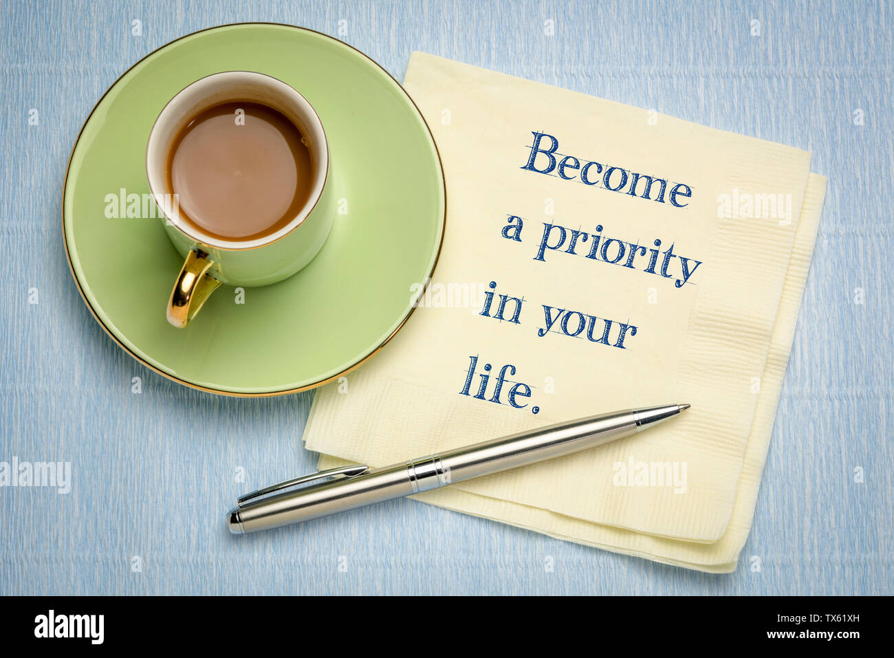 Wird eine Priorität in Ihrem Leben - inspirational Handschrift auf Serviette mit einer Tasse Kaffee Stockfoto