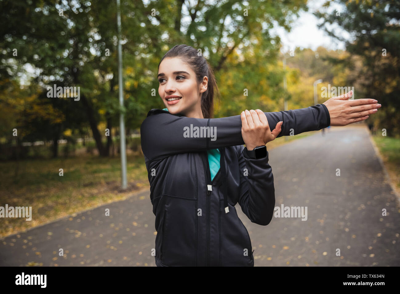 Lächelnden jungen Fitness Mädchen Übungen im Park Stockfoto