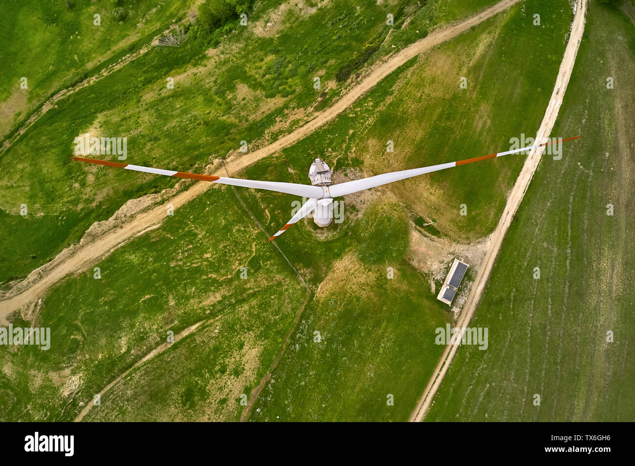 Ansicht von oben auf eine Windkraftanlage auf dem grünen Feld mit Landstraßen. Es gibt Lkw in der Nähe von Es. Antenne horizontal Foto. Stockfoto