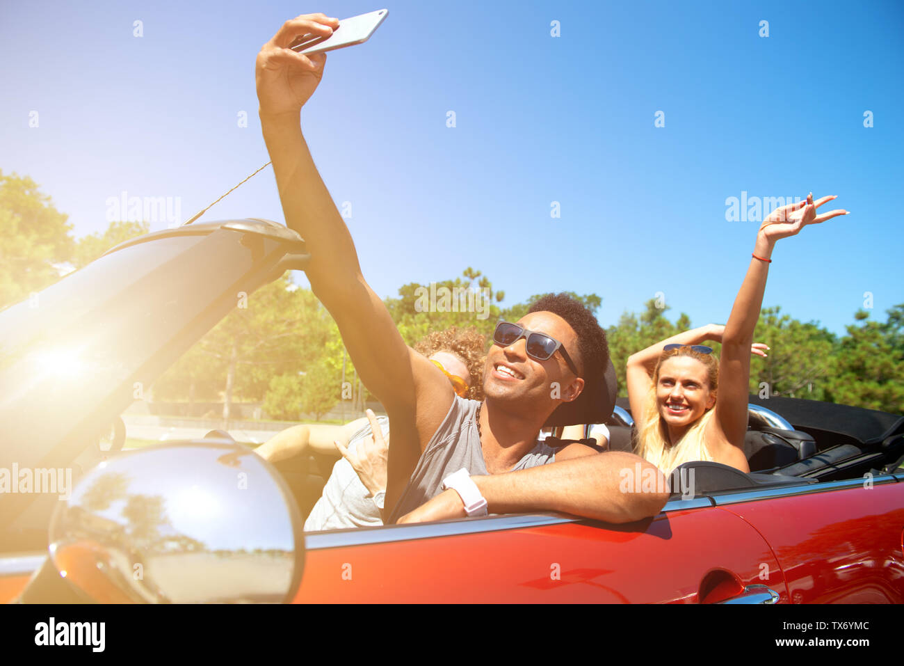 Junge Freunde nehmen ein Selbstporträt in einem Cabrio Auto Stockfoto