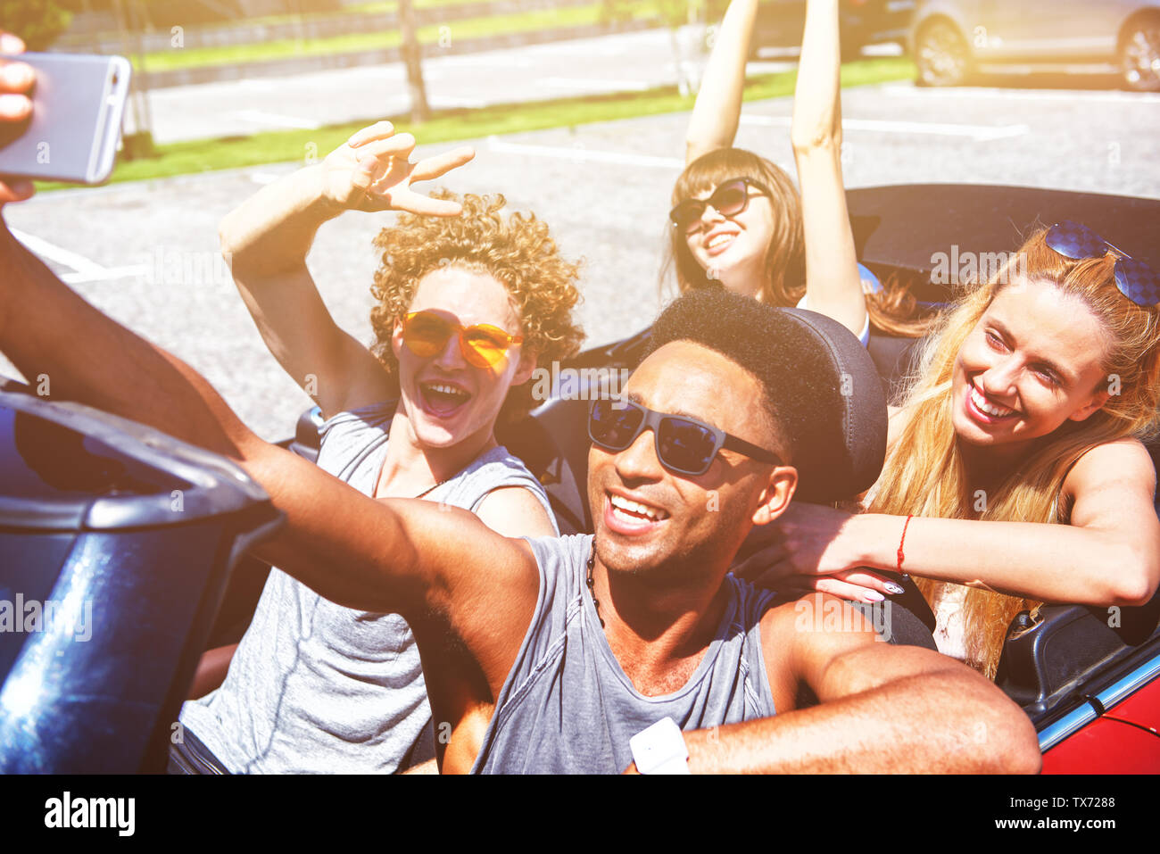 Junge Freunde nehmen ein Selbstporträt in einem Cabrio Auto Stockfoto